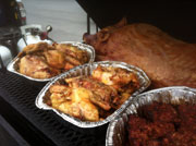 A pig shares the grill with chicken and sausage