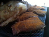 Rubbed brisket begins smoking along wtih pig